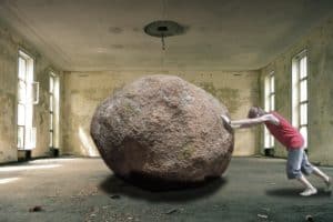 man pushing a boulder